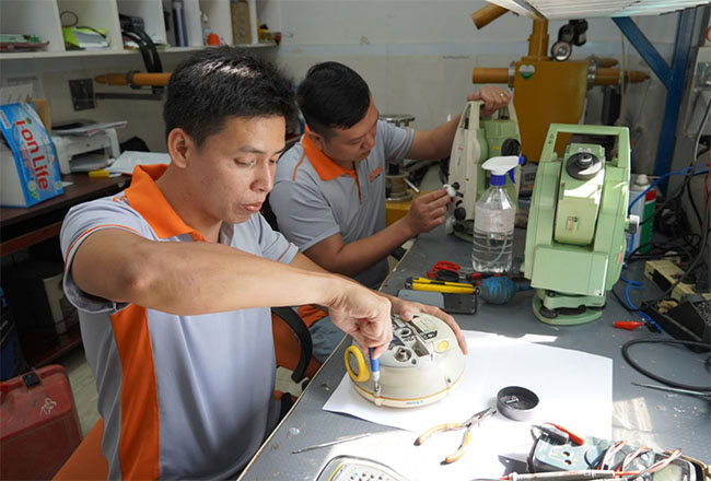 Chuyên viên kỹ thuật tại Trung tâm Kiểm định - Sửa chữa máy đo đạc Đất Hợp đang kiểm tra và sửa máy định vị GNSS cho khách hàng.